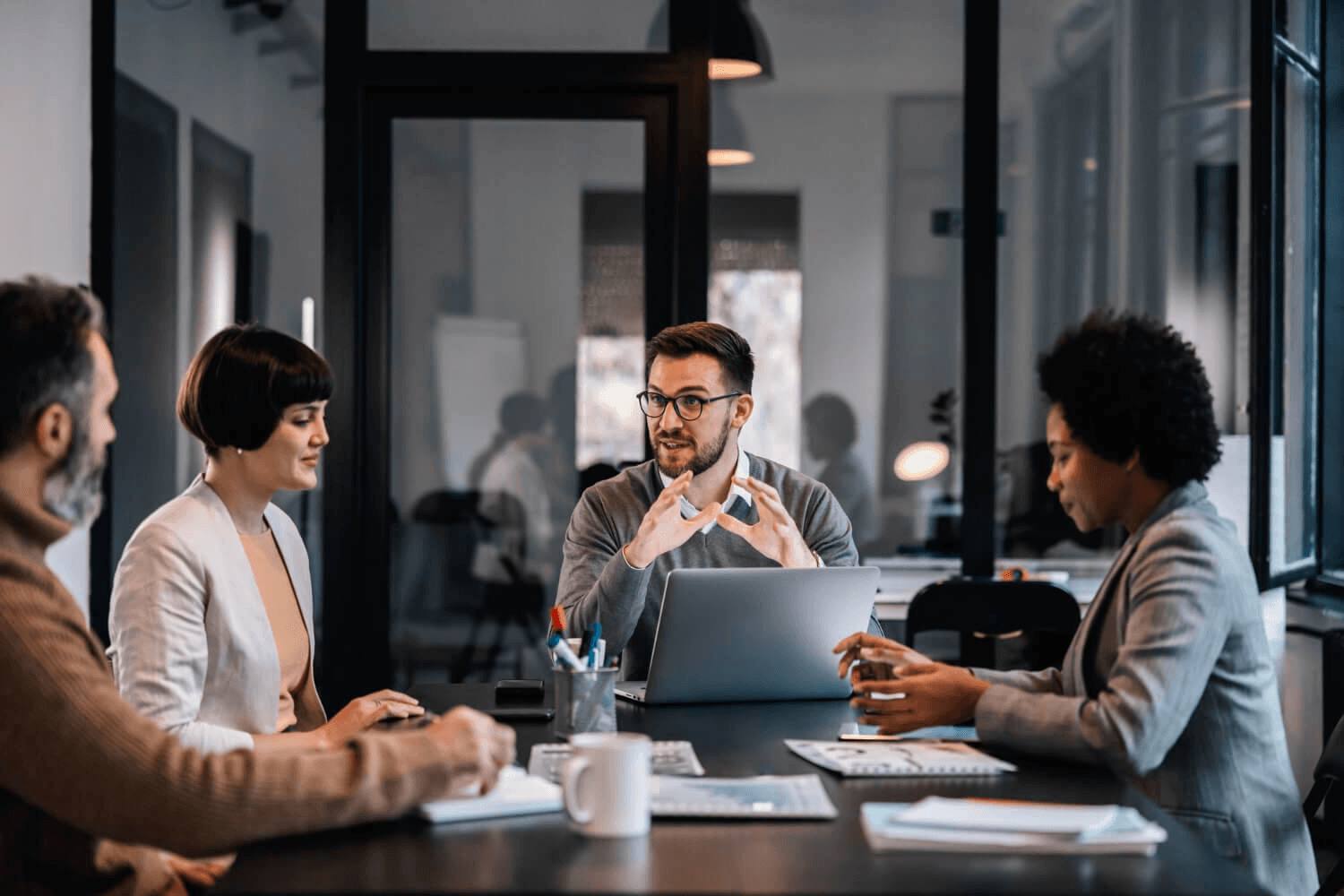 Delegates in discussion around a boardroom table during a business meeting